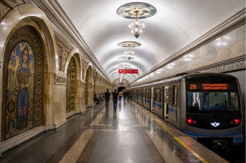 Interior of Yerevan Metro station with Armenian mosaics, subway train and Soviet-era architecture
