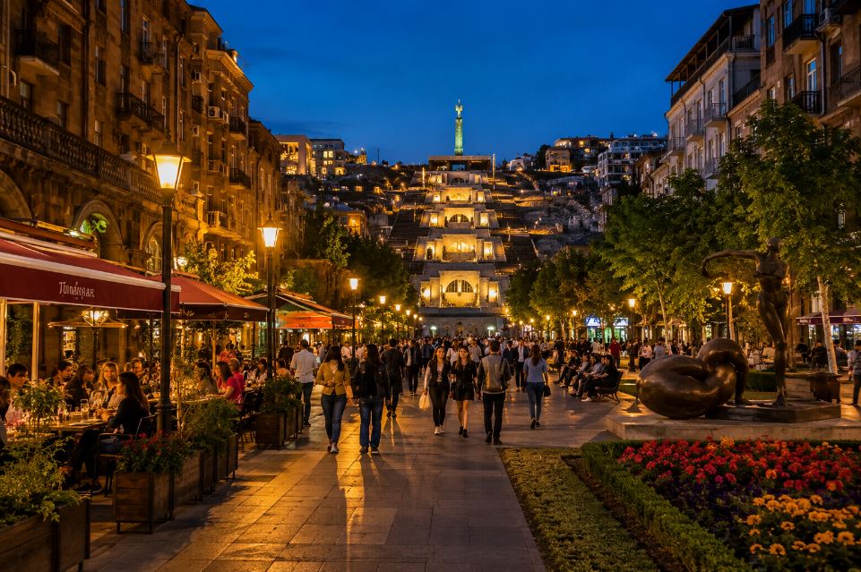 Evening pedestrian street in Yerevan with cafés, Cascade Complex and people enjoying the city at night