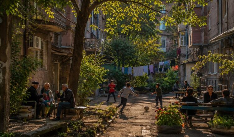 Traditional residential courtyard in Yerevan with children playing and neighbors socializing