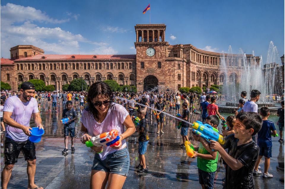 People celebrating Vardavar with water guns near the fountains in Republic Square, Yerevan